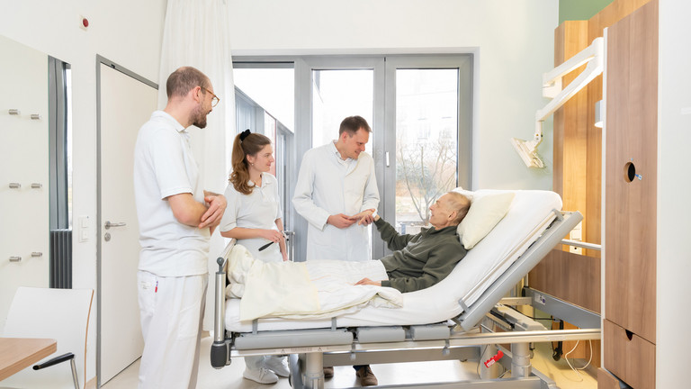 Prof. Kamp mit zwei Studierenden am Bett eines Palliativpatienten Prof. Kamp mit zwei Studierenden am Bett eines Palliativpatienten