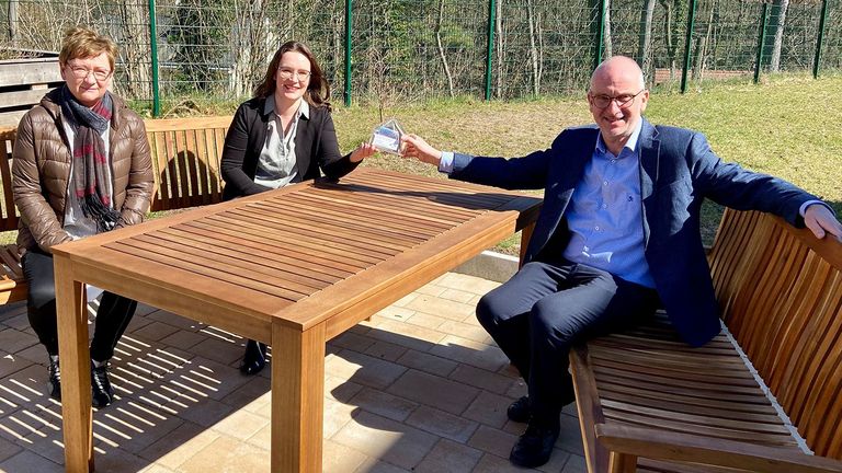 Karin und Stefanie Lange überreichen Walther Seiler ein prall gefülltes Spendenhäuschen, Nachrichten, Diakonie Hospiz Woltersdorf