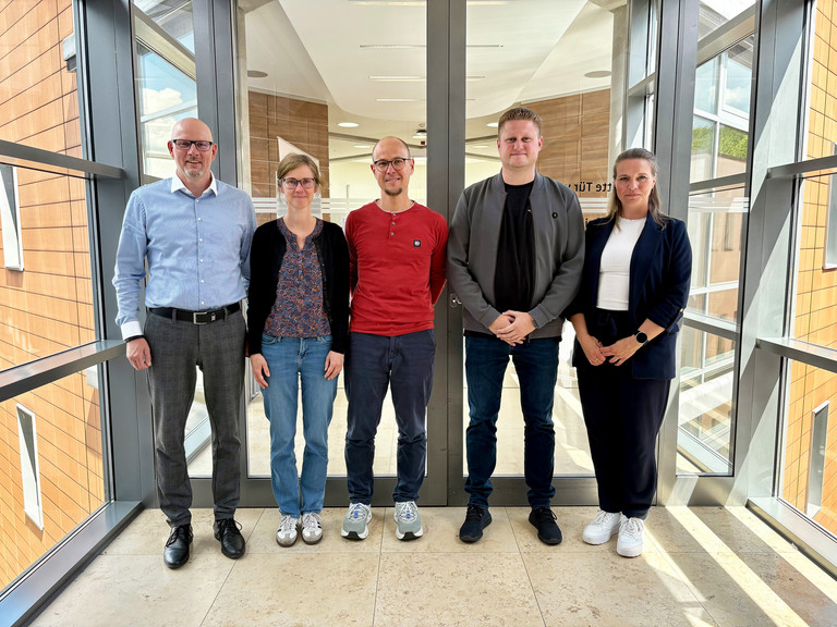 Von links nach rechts stehen Frank Volkmer, Michelle Geigenmüller, Alexander Reetz, Nico Nolte und Dr. Lydia Stübler nebeneinander in einem Gang in der Immanuel Klinik Rüdersdorf
