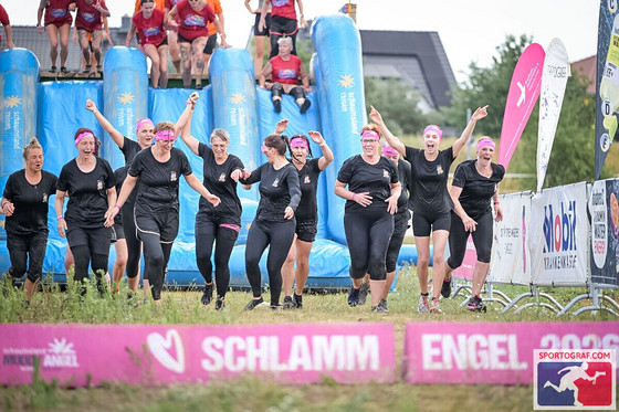 Kolleginnen der Immanuel Klinik Märkische Schweiz überwinden beim Muddy Angel Run in Berlin gemeinsam ein Hindernis und setzen ein Zeichen für Solidarität mit Brustkrebspatientinnen.