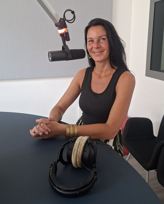 Kunsttherapeutin Sabrina Müller sitzt an einem Mikrofon im Studio von Radio Paradiso bei der Sendung über die Ermöglichung wertvoller und erfüllter Momente am Lebensende im Diakonie Hospiz Woltersdorf. Kunsttherapeutin Sabrina Müller sitzt an einem Mikrofon im Studio von Radio Paradiso bei der Sendung über die Ermöglichung wertvoller und erfüllter Momente am Lebensende im Diakonie Hospiz Woltersdorf.