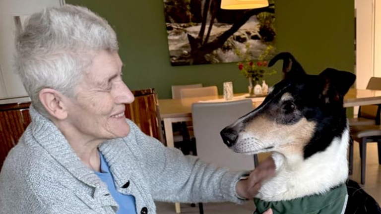 Hospizgast streichelt einen Therapiehund im Diakonie Hospiz Woltersdorf