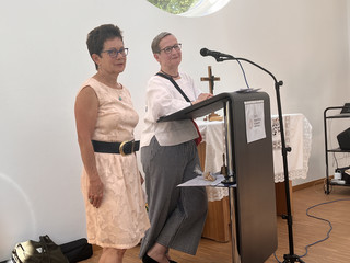 Beate Korn (links) und Cornelia Heine stehen vor einem Rednerpult mit Mikrofon bei der Jubiläumsfeier zum 15-jährigen Bestehen des Fördervereins „Polarstern“ Neuenhagen e. V. zur Unterstützung des Diakonie Hospiz Woltersdorf im Gemeindesaal der Ev. Verheißungskirchengemeinde Neuenhagen-Dahlwitz.