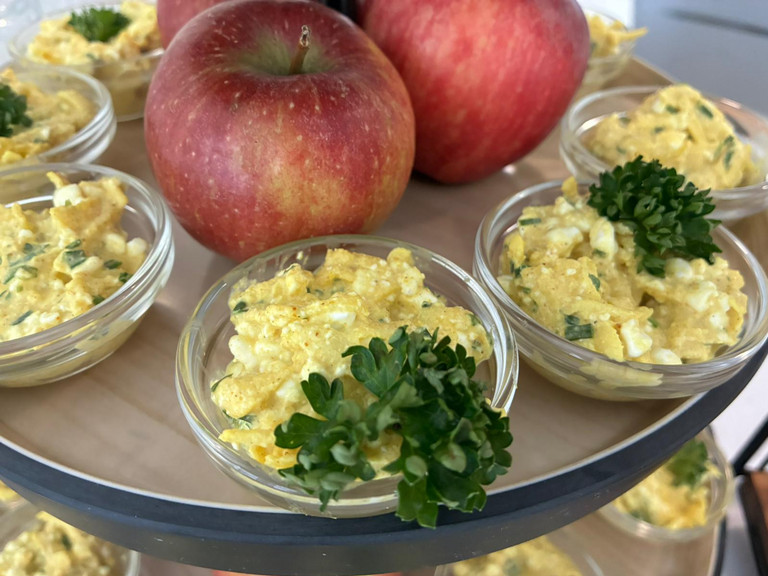 Zwei Äpfel auf Platte mit Apfel-Curry-Aufstrich in Schälchen