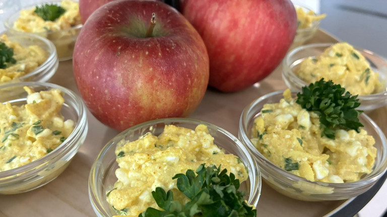 Zwei Äpfel auf Platte mit Apfel-Curry-Aufstrich in Schälchen